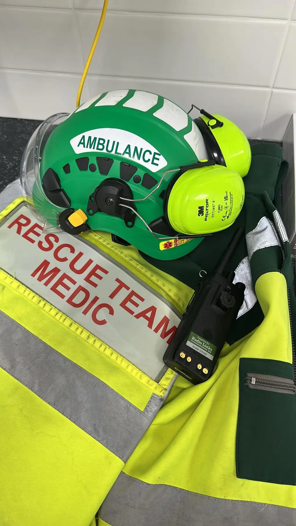 Rescue team medic helmet, radio and high-visibility medical jacket prepared for construction site medical cover.