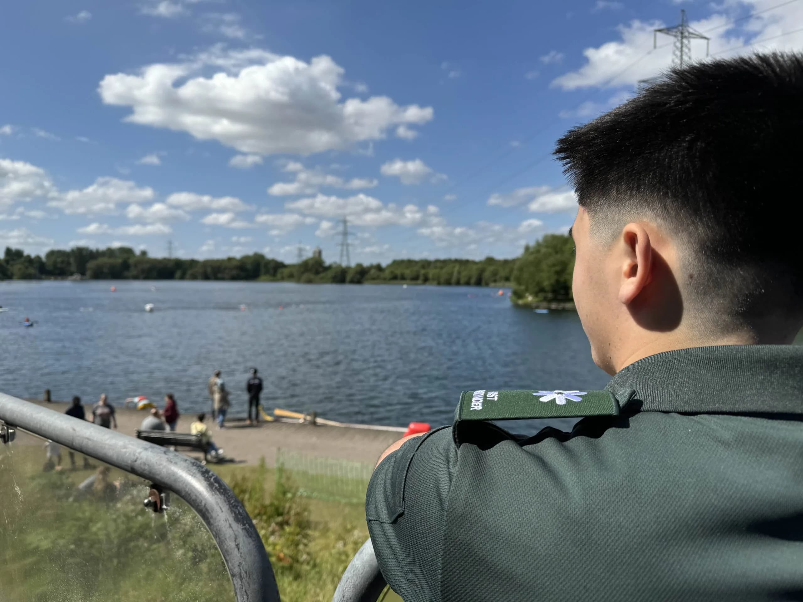 LightMed responder overlooking a lakeside event area with people near the water on a clear day.